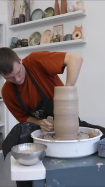 Çömlekçi çarkında çalışan bir adam. Dikey video