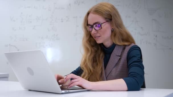 高加索女科学家在笔记本电脑上打字 有公式的白板 — 图库视频影像