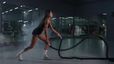 Beyaz kadın halatlarla egzersiz yapıyor. Spor salonunda tur eğitimi.