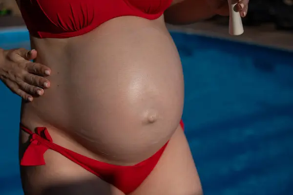 Close Belly Pregnant Woman Sunbathing Red Bikini Expectant Mother Applies — Stock Photo, Image