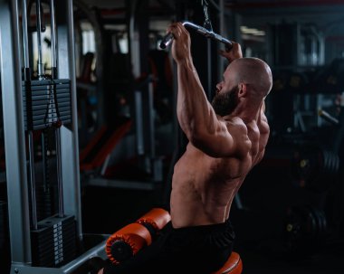 Kafkasyalı bir adam bir makinede çekiş yapıyor.