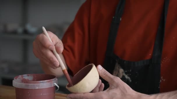 Close Van Een Pottenbakker Handen Met Een Borstel Schilderen Keramische — Stockvideo