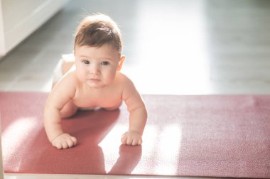 Yerde dört ayak üstünde duran sevimli küçük çocuk.