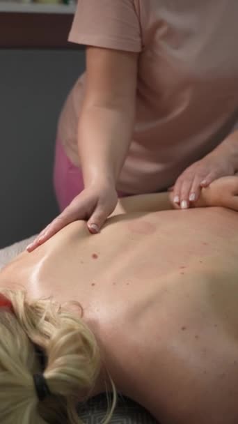 有治疗性背部按摩的女人 按摩师把肌肉跪在肩头刀刃下 垂直录像 — 图库视频影像
