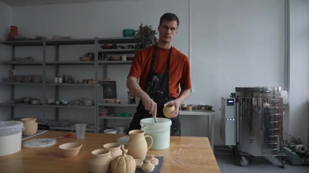 Een Pottenbakker Brengt Glazuur Aan Een Keramische Pot Met Een — Stockvideo
