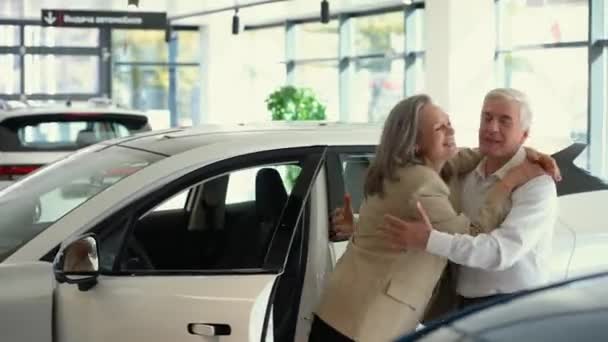 成熟的白种人夫妇在买新车时高兴地拥抱在一起 — 图库视频影像