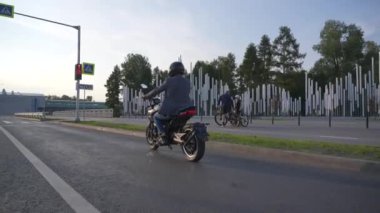 Kafkas bir adamın elektrikli motosiklet sürüşünün arka görüntüsü.