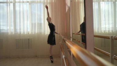 Kafkasyalı sarışın kadın sınıfta bale çalışıyor. Balerin barda prova yapıyor.