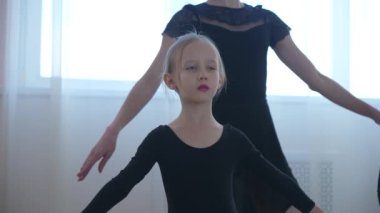 Çocuk bale okulu. Beyaz kadın küçük kızlara bale öğretiyor.