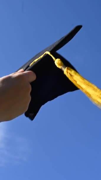 青空に対する卒業キャップを持つ女性のクローズアップ バーティカルビデオ — ストック動画