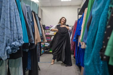 Şişman bir kadın büyük boy mağazadan kıyafet seçer.