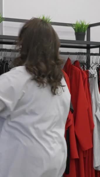 Een Dikke Vrouw Kiest Kleren Uit Proberen Een Size Winkel — Stockvideo