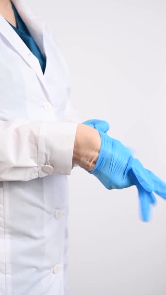 Der Arzt Zieht Latex Handschuhe Auf Weißem Grund Vertikales Video — Stockvideo