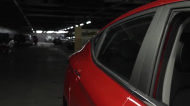 Kamera, araba galerisindeki kırmızı bir arabanın üzerinde süzülüyor.
