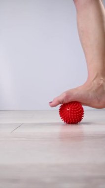 Çivili masaj topuna basan bir kadının yakın çekimi. Dikey video