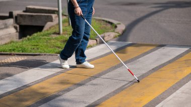 Yaya geçidinden sopayla geçen kör bir kadının bacaklarına yakın çekim.