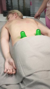 Masöz, müşterilere masaj yaparken vakumlu plastik kutular kullanıyor. Dikey video