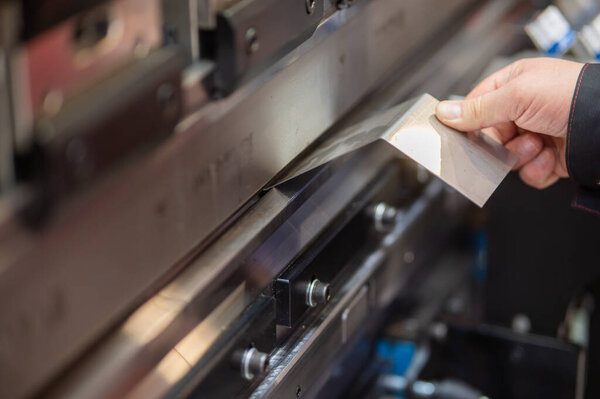 A master bends metal sheets on a machine. Hydraulic Press