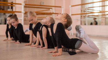 Beş küçük kız basket egzersizi yapıyor.
