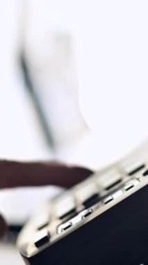 Close-up of the hand of a female office worker dialing a number on a landline phone. Faceless woman secretary calls on the phone. Vertical video
