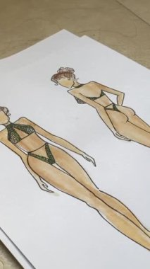Woman looking at sketches of underwear. Vertical video