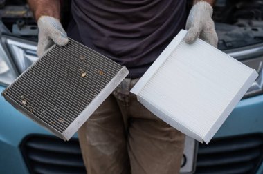 Usta arabanın kabin hava filtresini değiştiriyor.