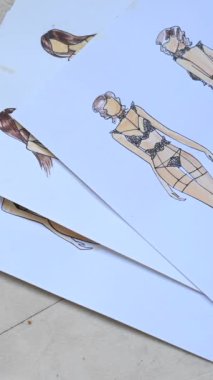 Woman looking at sketches of underwear. Vertical video