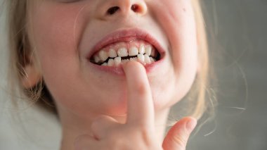 Çikolataya bulanmış şirin küçük bir kız kanepede yatarken kurabiye yiyor.