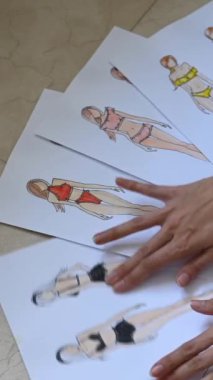 Woman looking at sketches of underwear. Vertical video