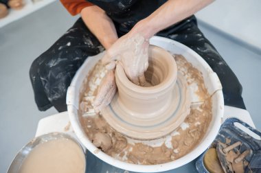 Çömlek çarkında çalışan çömlekçilerin yakın çekimi.