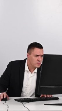 Adam sinirleniyor ve klavyeyi monitörde parçalıyor. Öfkeli bir ofis çalışanı bilgisayarı bozar. Ağır çekim. Dikey video