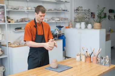 A potter kneads clay before using it in the workshop. Close-up of a mans hands