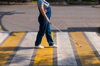 Yaya geçidinden sopayla geçen kör bir kadının bacaklarına yakın çekim.