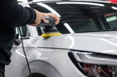 Yörüngesel cilalama makinesi kullanılarak beyaz arabanın kaput yüzeyinin parlatılması işlemi