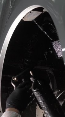 Üstat arabanın altına korozyon önleyici bir bileşik püskürtüyor. Dikey video