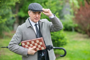 Dışarıda satranç oynayan yaşlı beyaz bir adam.