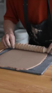 Çömlekçi ellerinin yakın plan çekimleri, şekilli merdane kullanarak kilden yapılmış. Dikey video