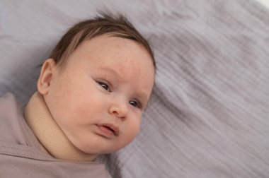 Top view of a newborn baby wearing an orthopedic collar clipart