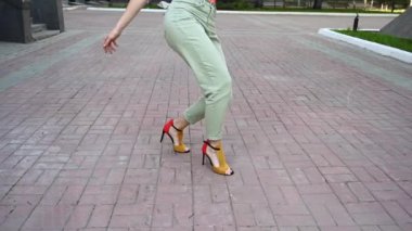  Dışarıda yüksek topuklularla dans eden kadın. Kadınların bacaklarına yakın çekim