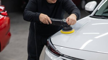 Yörüngesel cilalama makinesi kullanılarak beyaz arabanın kaput yüzeyinin parlatılması işlemi