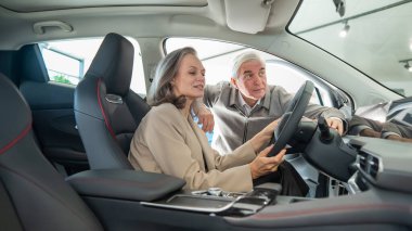 Yaşlı bir çift bir araba galerisinde yeni bir araba seçer. Olgun kadın sürüyor.