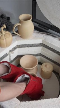 Erkek ellerinin seramikleri özel bir fırına götürdüğü yakın plan.