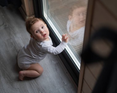 Bebek çocuk verandanın önünde duruyor.