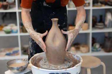 Close-up of a potters hands making a ceramic vase on a potters wheel clipart