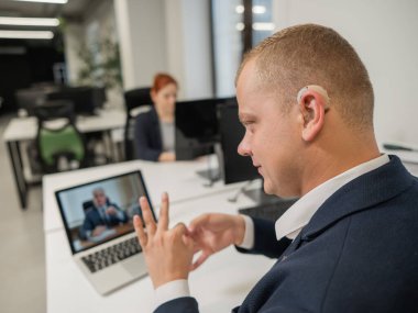 İş ortakları bir video görüşmesiyle işaret diliyle konuşuyor. Uzak bir iş görüşmesinde iki adam.