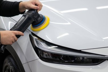 Yörüngesel cilalama makinesi kullanılarak beyaz arabanın kaput yüzeyinin parlatılması işlemi