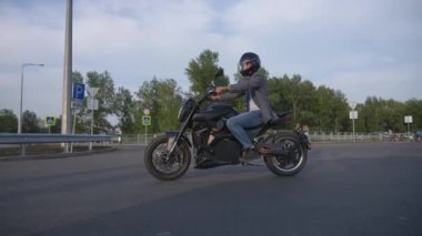 Beyaz adam elektrikli motosiklet kullanıyor.