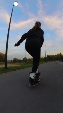Akşamları paten kayan beyaz kadın. Slalom. Dikey video