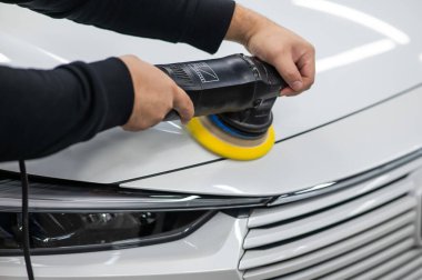 Yörüngesel cilalama makinesi kullanılarak beyaz arabanın kaput yüzeyinin parlatılması işlemi