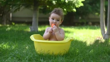 Tatlı erkek bebek yazın havuzda yıkanır.